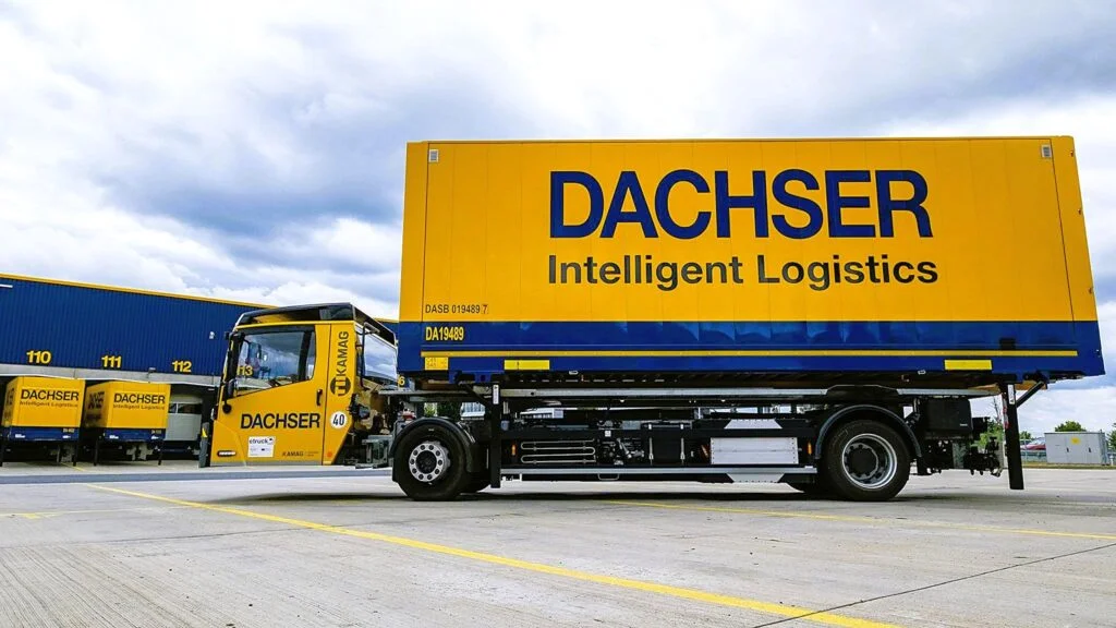 Ein elektrisch angetriebenes Wechselbrückenfahrzeug, auch Hochumsetzer genannt, steht auf dem Betriebshof der Niederlassung Erlensee, beladen mit einer Wechselbrücke mit DACHSER Aufschrift.