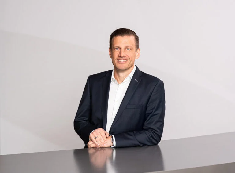 Porträt von Alexander Tonn, COO Road Logistics bei Dachser, vor grauem Hintergrund